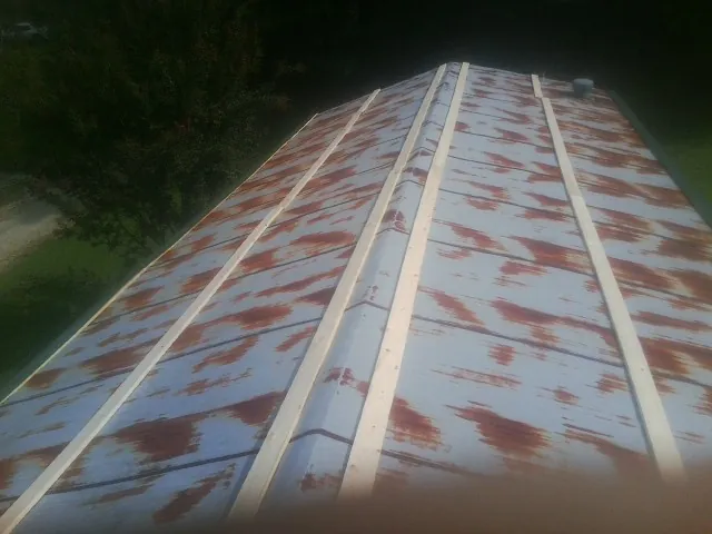 Rusted metal roof panels with new wood purlins before replacement — Storm Damage Roof Repair in Una by Roofing Brothers