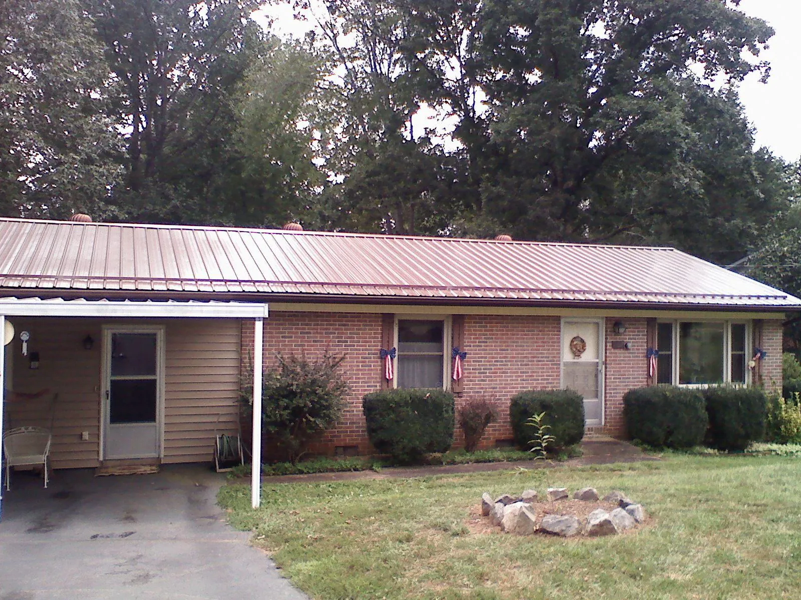 Bronze metal roof and carport on a brick ranch home — Roof Repair work by our crew in Una
